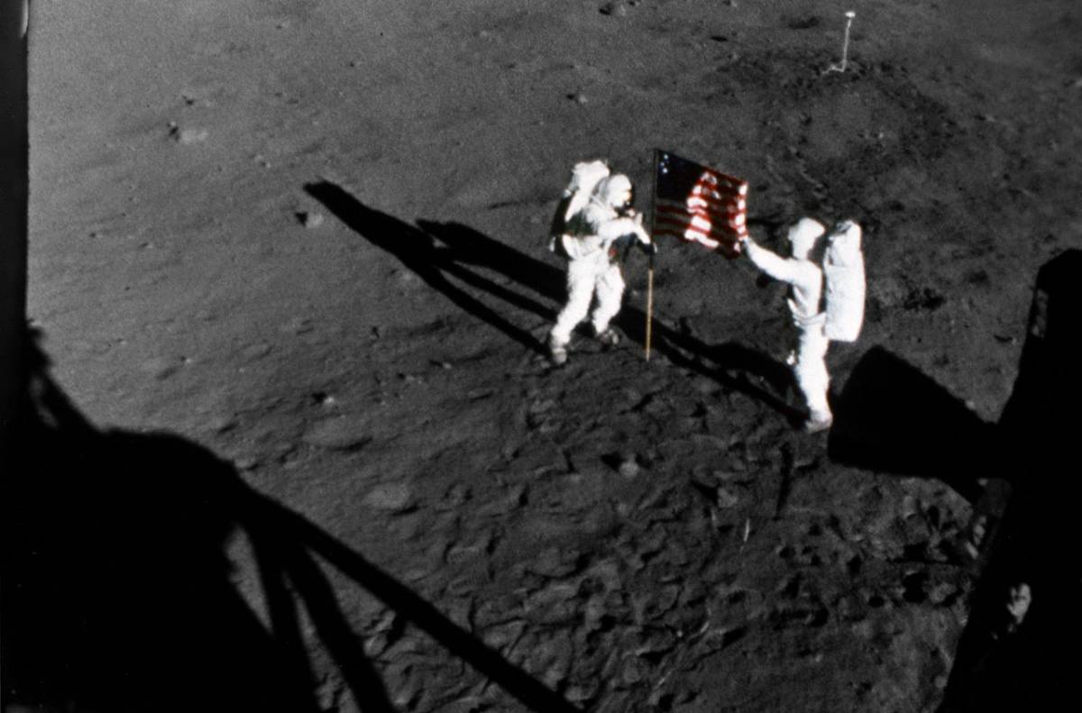 Армстронг (слева) и Олдрин устанавливают на Луне флаг США (съемка 16-мм кинокамерой лунного модуля) / ©NASA