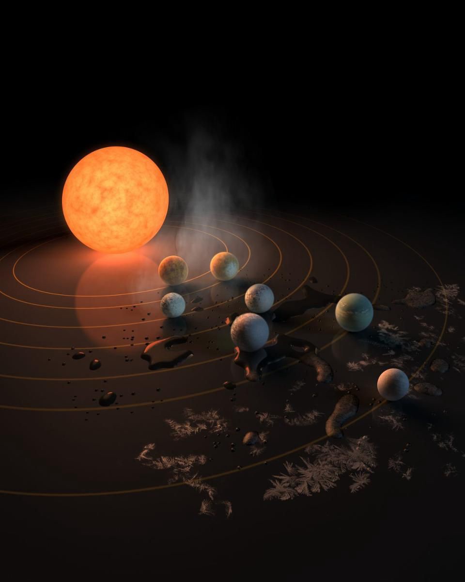 Система TRAPPIST-1 в представлении художника на отражающей поверхности. Вероятность присутствия воды на каждой планете системы представлена инеем, каплями воды и паром. Однако неизвестно, есть ли в каком-либо из этих миров атмосфера, или же ее давно сдуло звездой. Одно можно сказать наверняка: потенциально обитаемые миры расположены очень близко друг к другу — на расстоянии около одного миллиона километров / © NASA/R. Hurt/T. Pyle