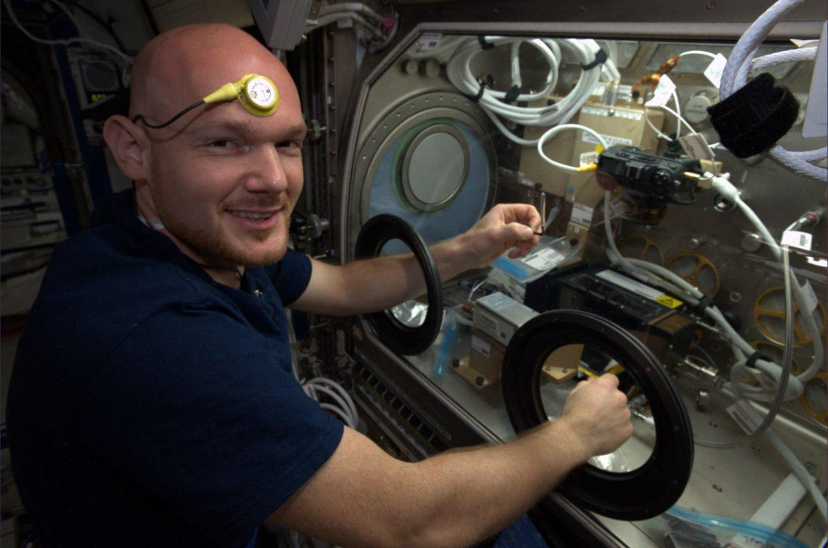 Немецкий астронавт Александр Герст во время работы. У него на лбу термодатчик, постоянно измеряющий температуру тела в рамках эксперимента Thermolab / © NASA